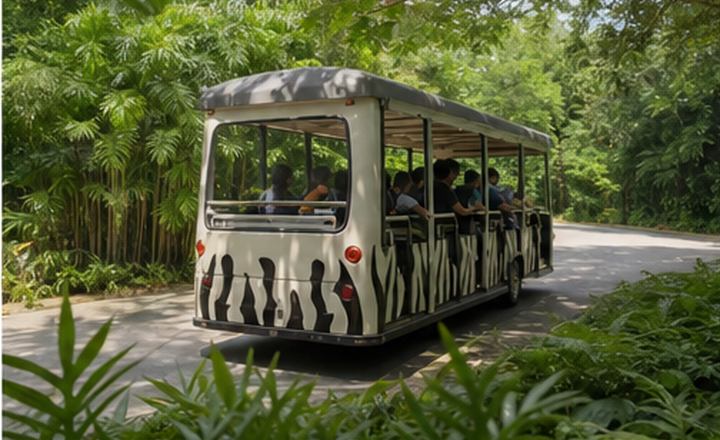 Trem bergerak melalui kawasan zoo yang hijau
